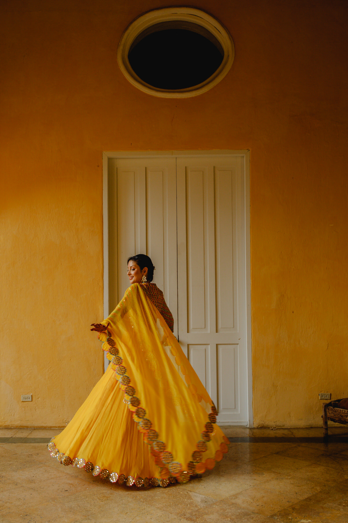 Elegant Indian bride in a captivating yellow attire at the Sangeet celebration at her destination Indian wedding in Cartagena. Photos by Take it Photo Weddings