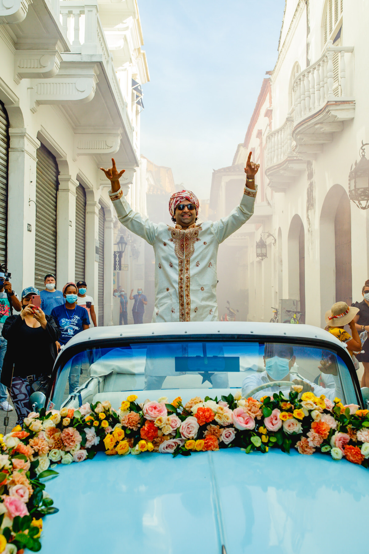 Festive baraat procession featuring the groom's grand arrival, accompanied by lively music and dancing in this Indian wedding in Cartagena.