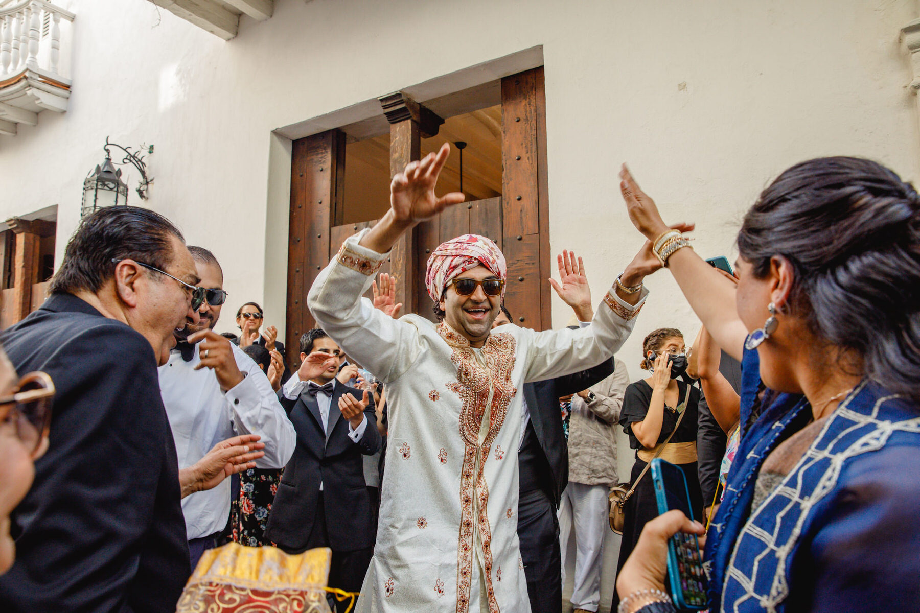 The Groom arriving to the location surrounded by a festive ambiance for his Indian wedding ceremony in Cartagena