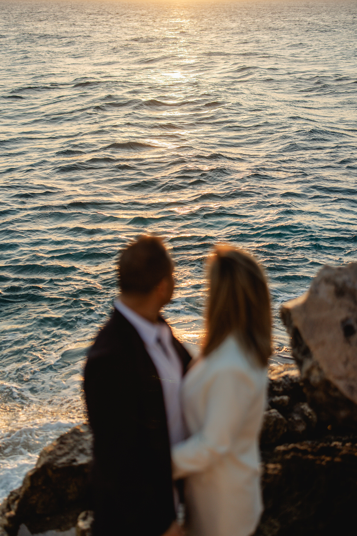 Romantic sunset engagement photo on Isla Mujeres, with the couple standing hand in hand